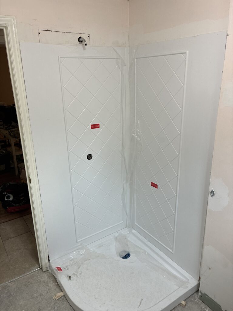 Installed acrylic shower wall panels fitted around the shower valve for a neo-angle shower kit in St. Thomas, Ontario.