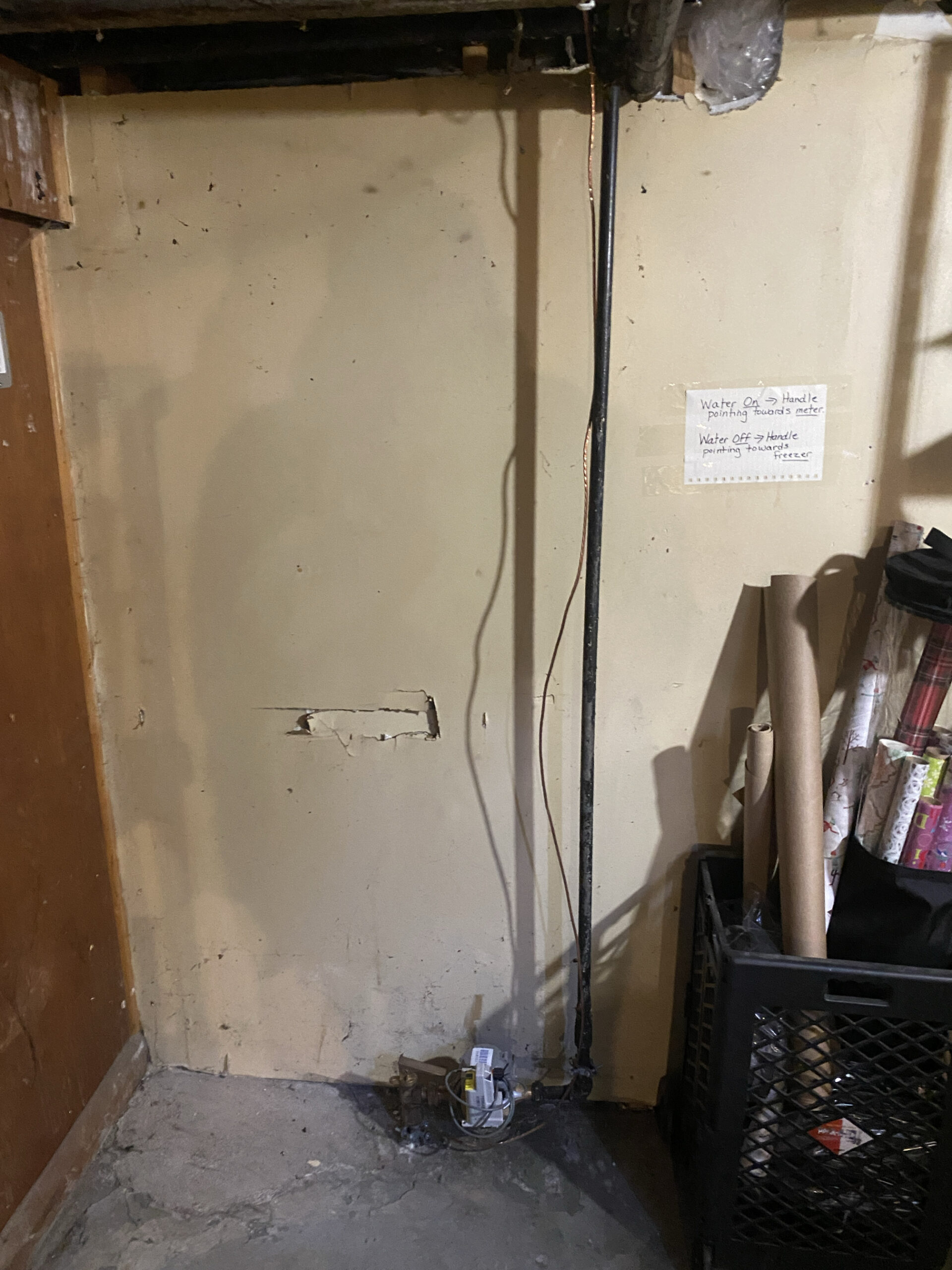 Old basement water meter setup with an upward-running galvanized iron water pipe prior to replacement in South London, Ontario.
