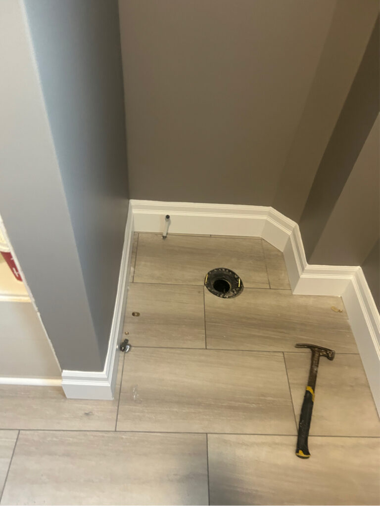 Subfloor preparation featuring an ABS toilet flange and copper water supply line ready for toilet installation in a St. Thomas home.