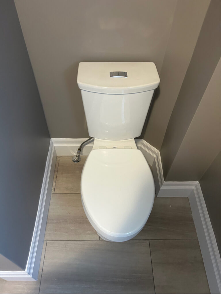 Newly installed water-efficient dual-flush toilet mounted on new bathroom flooring in a St. Thomas, Ontario home.
