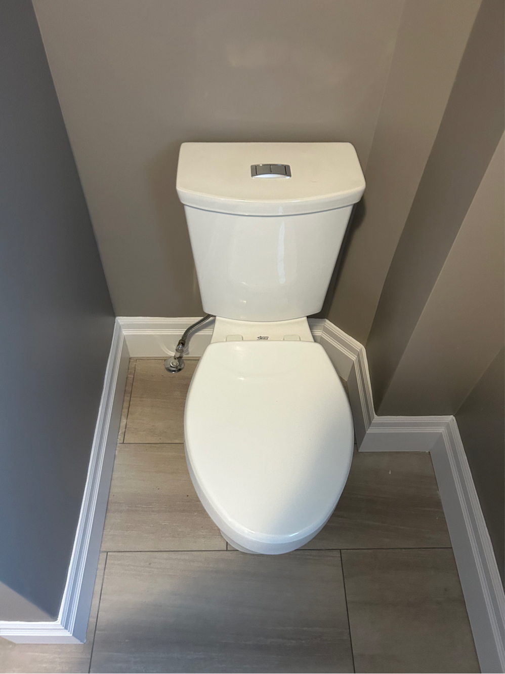 Newly installed water-efficient dual-flush toilet mounted on new bathroom flooring in a St. Thomas, Ontario home.