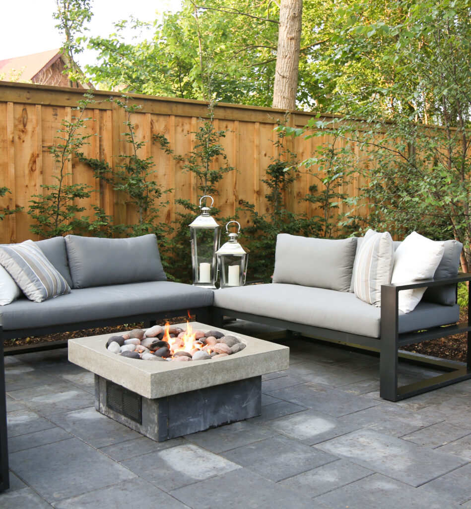 Outdoor patio seating area in Old South London featuring a new gas fire pit surrounded by an outdoor sofa.